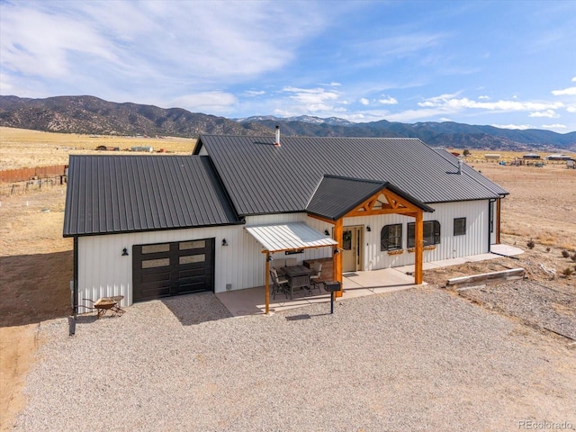 modern inspired farmhouse featuring a mountain view, a garage, and covered porch