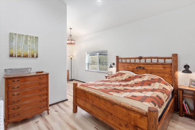 bedroom featuring a chandelier and light hardwood / wood-style floors