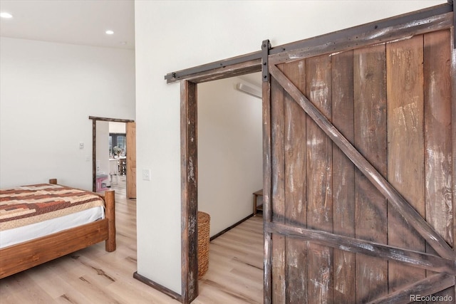 stairs with hardwood / wood-style floors, a towering ceiling, and a barn door