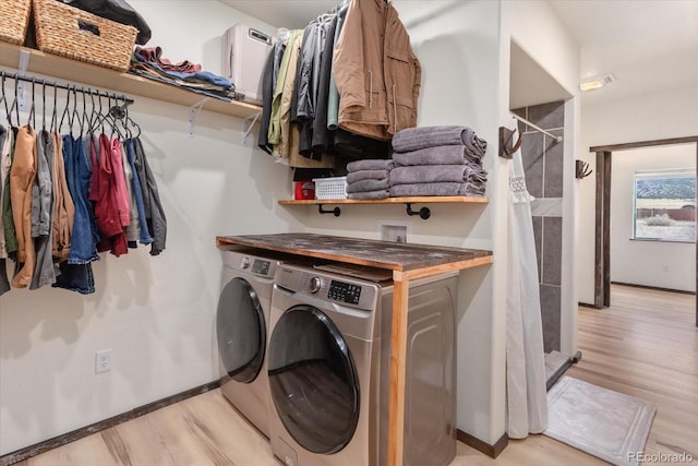 washroom with washer and dryer and light hardwood / wood-style floors