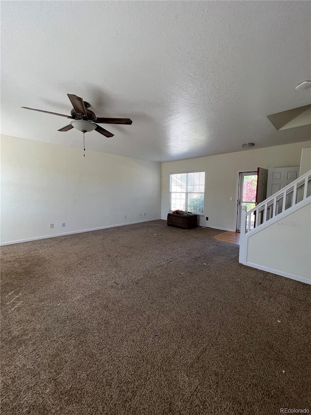 carpeted empty room featuring a textured ceiling and ceiling fan