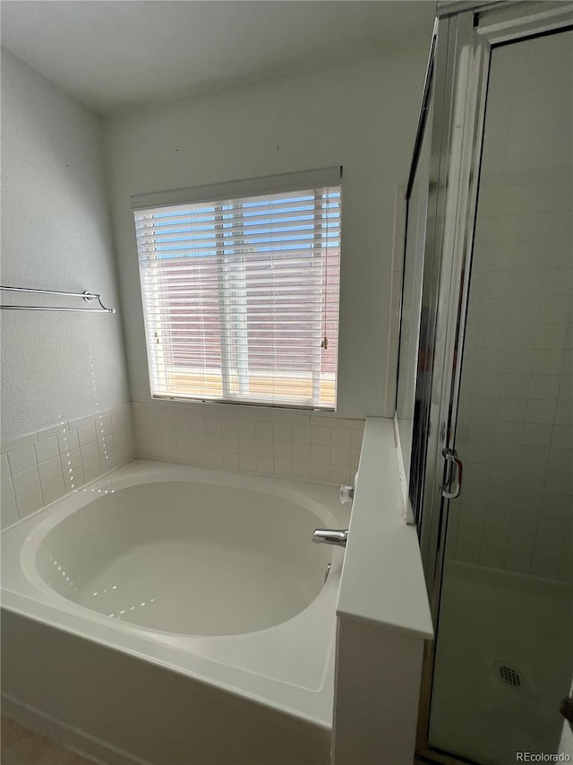 bathroom featuring separate shower and tub