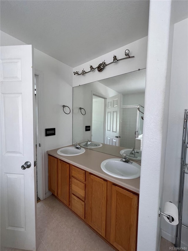 bathroom featuring a shower with door, tile patterned floors, a textured ceiling, and vanity