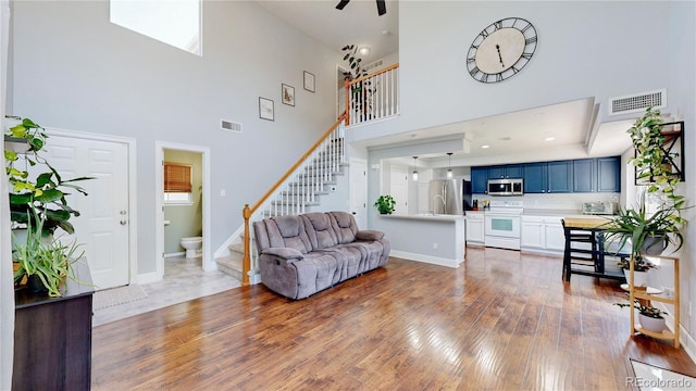 21570 E 40th Pl, Denver, CO 80249 - living room with stairway, a towering ceiling, and wood-type flooring