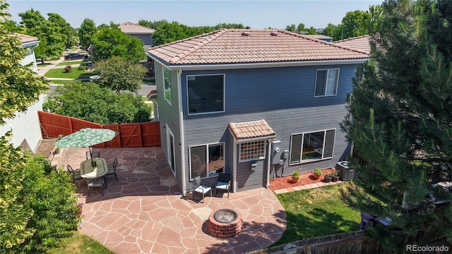 21570 E 40th Pl, Denver, CO 80249 - back of property with a patio area, a fire pit, a fenced backyard, and a tile roof