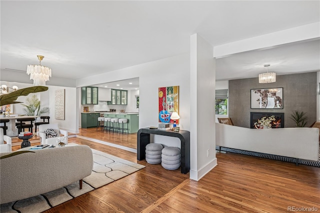 living area featuring a chandelier, light wood finished floors, baseboards, a tile fireplace, and recessed lighting
