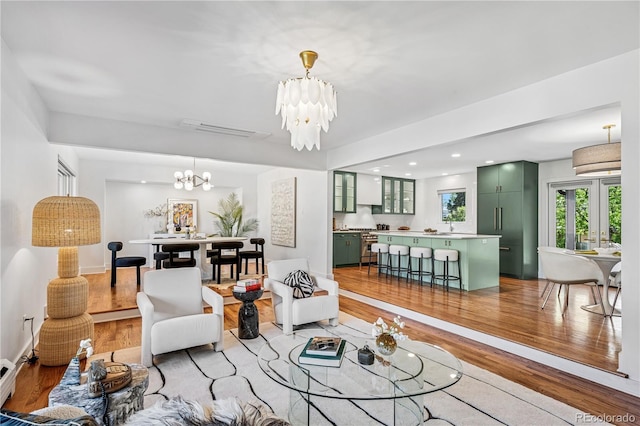 living area with a chandelier, light wood finished floors, and recessed lighting