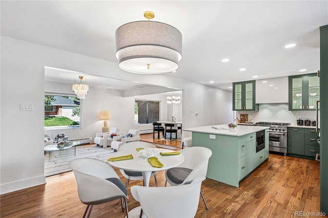 dining room with a chandelier, wood finished floors, recessed lighting, and baseboards