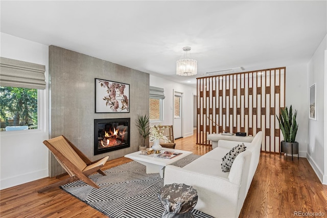 living room featuring wood finished floors, baseboards, and a chandelier