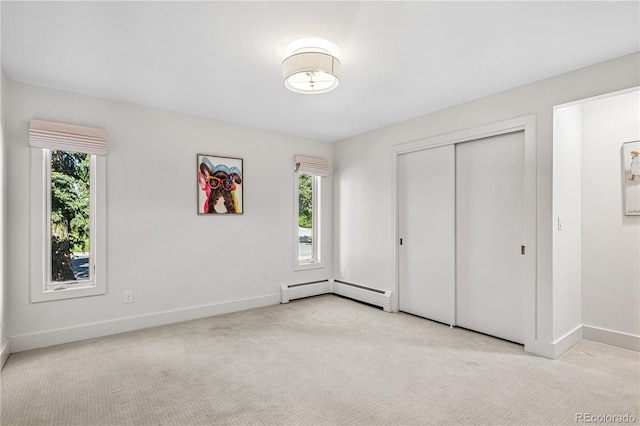unfurnished bedroom featuring multiple windows, carpet flooring, and baseboards