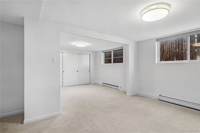 spare room with a baseboard radiator, carpet floors, and baseboards
