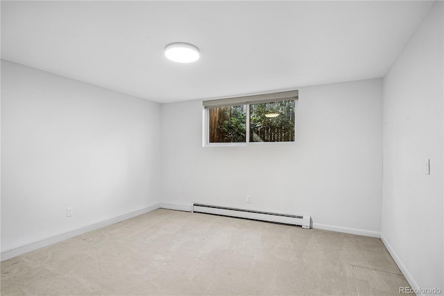 carpeted spare room with a baseboard radiator and baseboards