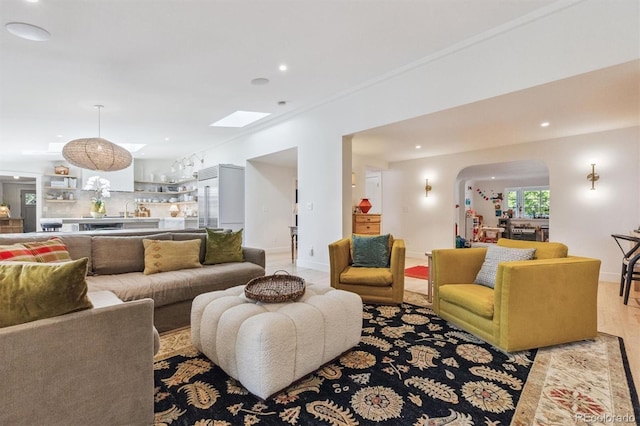 435 Ivanhoe St, Denver, CO 80220 - living area with arched walkways, recessed lighting, and light wood-style flooring