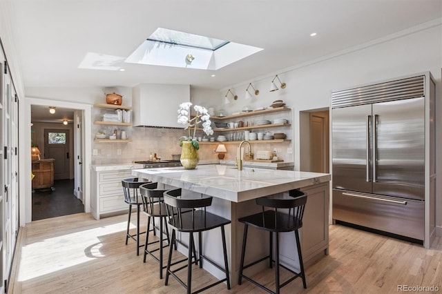 435 Ivanhoe St, Denver, CO 80220 - kitchen featuring built in refrigerator, open shelves, a skylight, light stone counters, and recessed lighting
