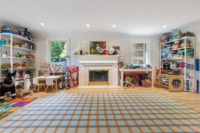 435 Ivanhoe St, Denver, CO 80220 - recreation room with wood finished floors, a glass covered fireplace, and recessed lighting