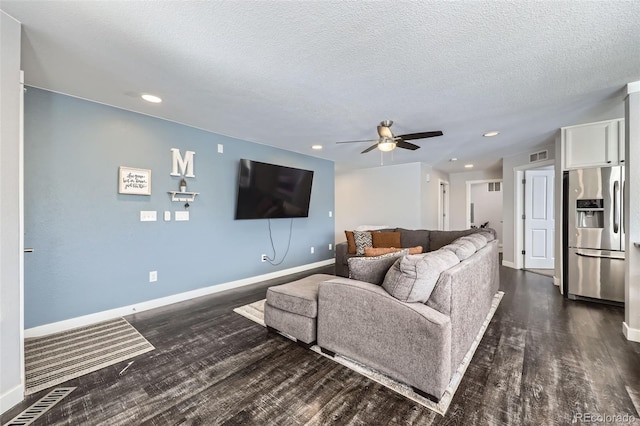 living room featuring dark wood finished floors, visible vents, a ceiling fan, a textured ceiling, and baseboards