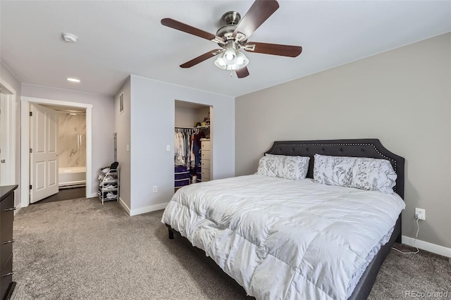 bedroom with a walk in closet, baseboards, and dark colored carpet