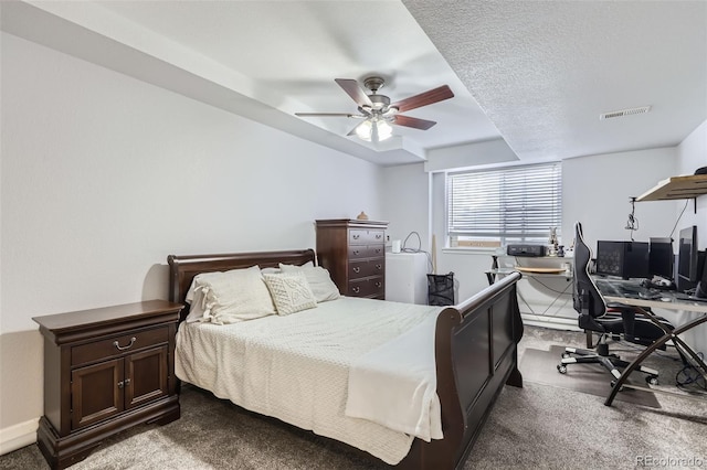 bedroom featuring carpet, a textured ceiling, visible vents, and a ceiling fan