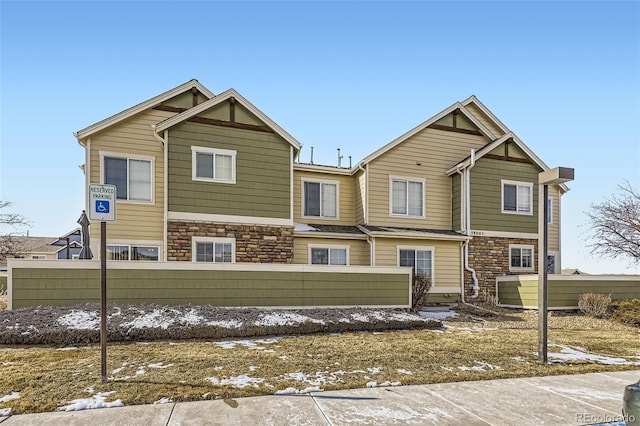 view of front of home with a fenced front yard and stone siding