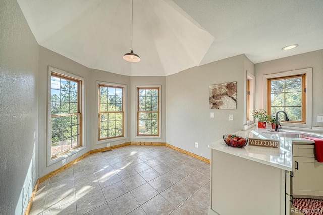 318 Southgate Rd, Florissant, CO 80816 - unfurnished dining area with a textured wall, baseboards, light tile patterned floors, and a sink