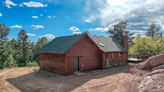 318 Southgate Rd, Florissant, CO 80816 - view of side of home with a chimney, roof with shingles, and a wooden deck