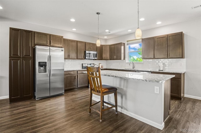 7956 Osage St, Denver, CO 80221 - kitchen with stainless steel appliances, dark wood-type flooring, tasteful backsplash, recessed lighting, and a center island