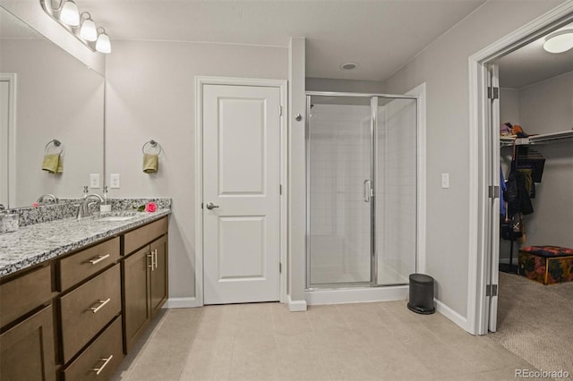 7956 Osage St, Denver, CO 80221 - bathroom with vanity, a shower stall, a spacious closet, and tile patterned flooring