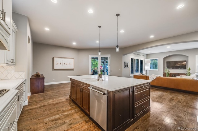2362 Spruce Way, Denver, CO 80238 - kitchen featuring stainless steel dishwasher, a sink, arched walkways, light countertops, and white cabinetry