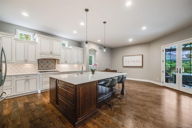 2362 Spruce Way, Denver, CO 80238 - kitchen featuring arched walkways, light countertops, dark wood-type flooring, french doors, and a breakfast bar