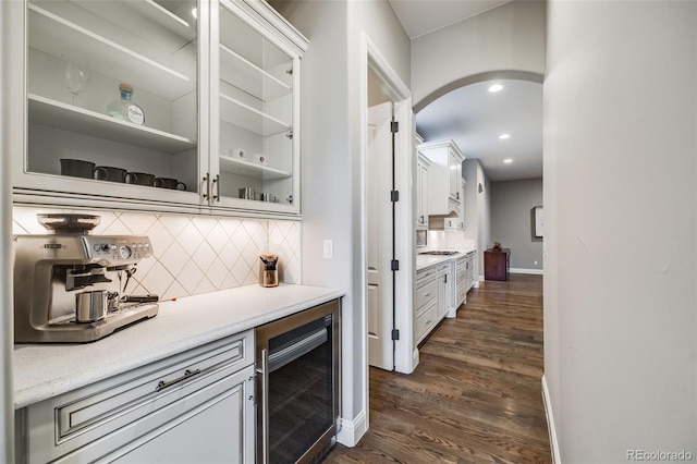 2362 Spruce Way, Denver, CO 80238 - indoor dry bar with beverage cooler, tasteful backsplash, arched walkways, dark wood-style flooring, and baseboards