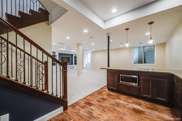 2362 Spruce Way, Denver, CO 80238 - kitchen featuring stainless steel microwave, dark brown cabinetry, light wood finished floors, decorative light fixtures, and open floor plan