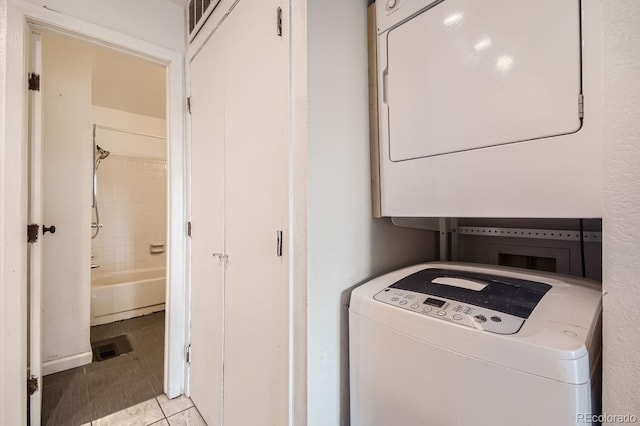 laundry room with laundry area, stacked washer and clothes dryer, and light tile patterned floors