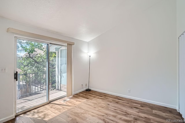empty room featuring baseboards, visible vents, and wood finished floors