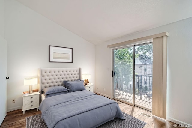 bedroom with lofted ceiling, wood finished floors, baseboards, and access to exterior