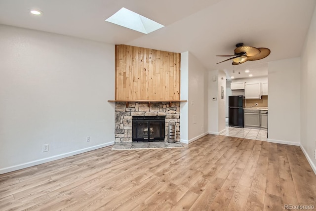 63 S Sable Blvd Unit E22, Aurora, CO 80012 - unfurnished living room featuring a skylight, light wood finished floors, a fireplace, recessed lighting, and a ceiling fan