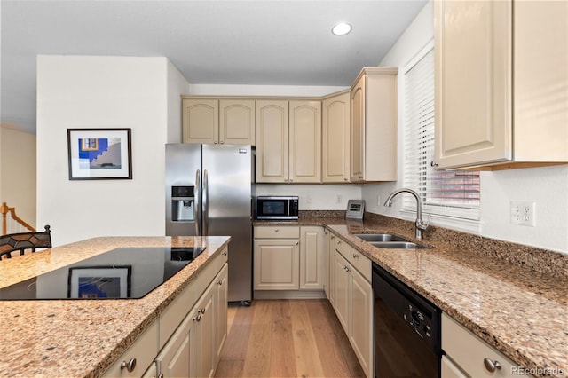 1901 S Union Pl, Lakewood, CO 80228 - kitchen with black appliances, light wood-type flooring, cream cabinets, light stone counters, and recessed lighting
