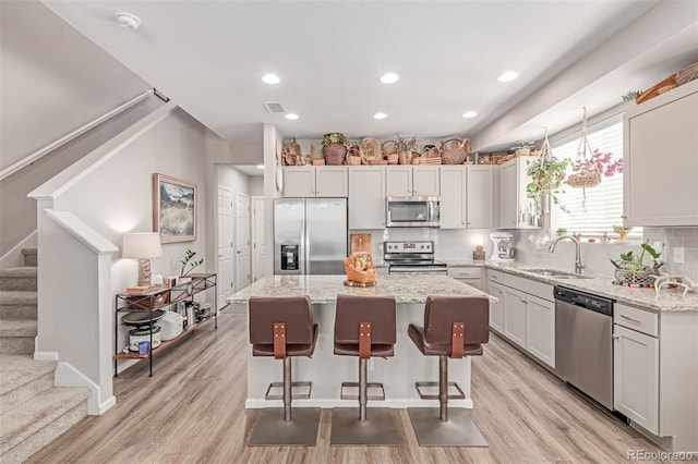 4790 Kittredge St, Denver, CO 80239 - kitchen with stainless steel appliances, a kitchen island, tasteful backsplash, light wood finished floors, and recessed lighting