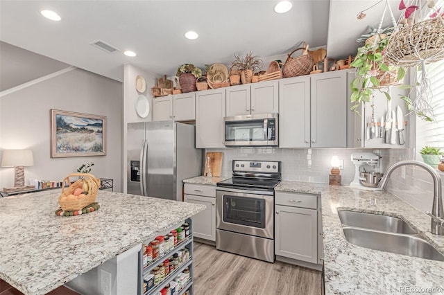 4790 Kittredge St, Denver, CO 80239 - kitchen with stainless steel appliances, decorative backsplash, light stone countertops, light wood-style floors, and recessed lighting