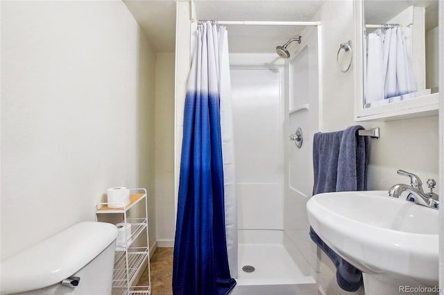 bathroom with walk in shower, tile patterned flooring, toilet, and sink