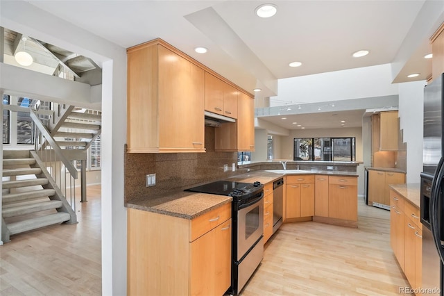 kitchen featuring tasteful backsplash, light wood-style flooring, a peninsula, and stainless steel appliances