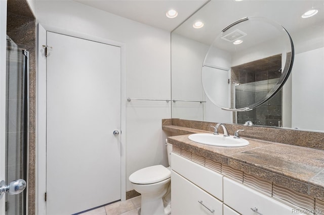 bathroom with vanity, a shower with shower door, recessed lighting, tile patterned floors, and toilet