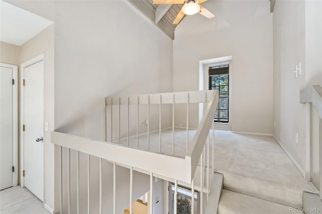 staircase featuring baseboards, carpet floors, and ceiling fan