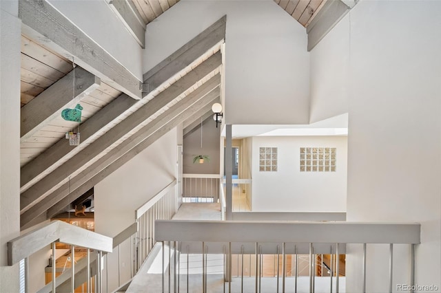 staircase with wood ceiling and lofted ceiling with beams