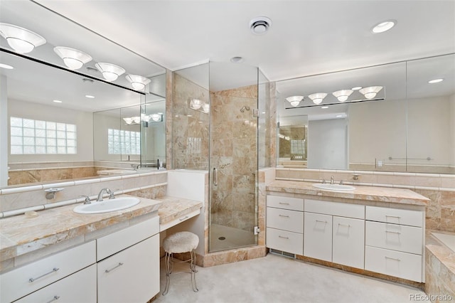 full bathroom featuring a shower stall, two vanities, visible vents, and a sink