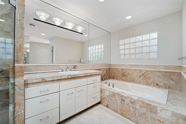 full bath with recessed lighting, a stall shower, vanity, and a garden tub