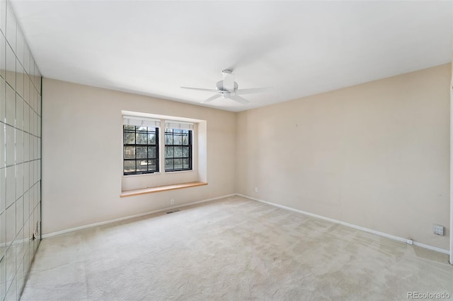 carpeted spare room featuring visible vents, baseboards, and a ceiling fan