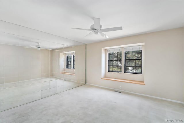 spare room featuring visible vents, baseboards, carpet, and ceiling fan