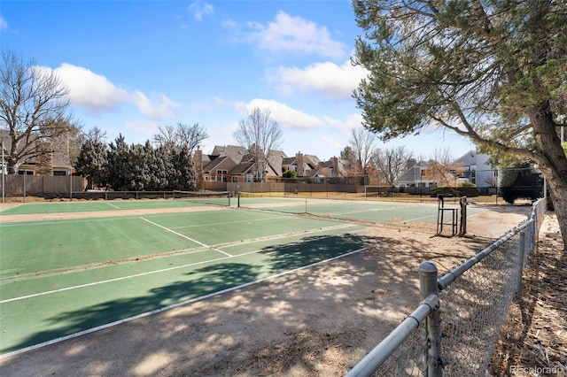 view of sport court with fence and a residential view