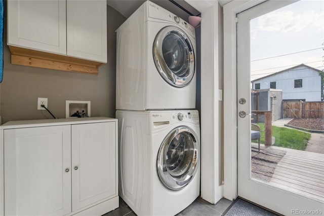 3881 Zenobia St, Denver, CO 80212 - laundry room featuring stacked washer / dryer and cabinet space