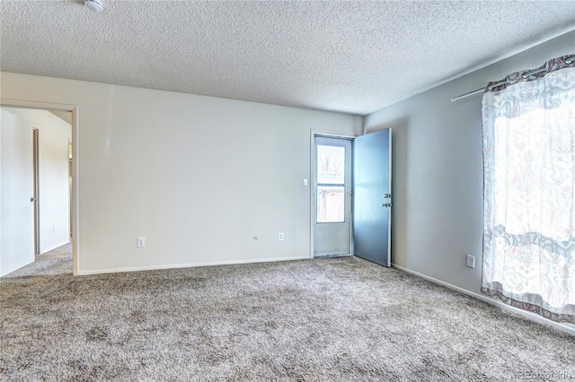 unfurnished room featuring carpet and a textured ceiling